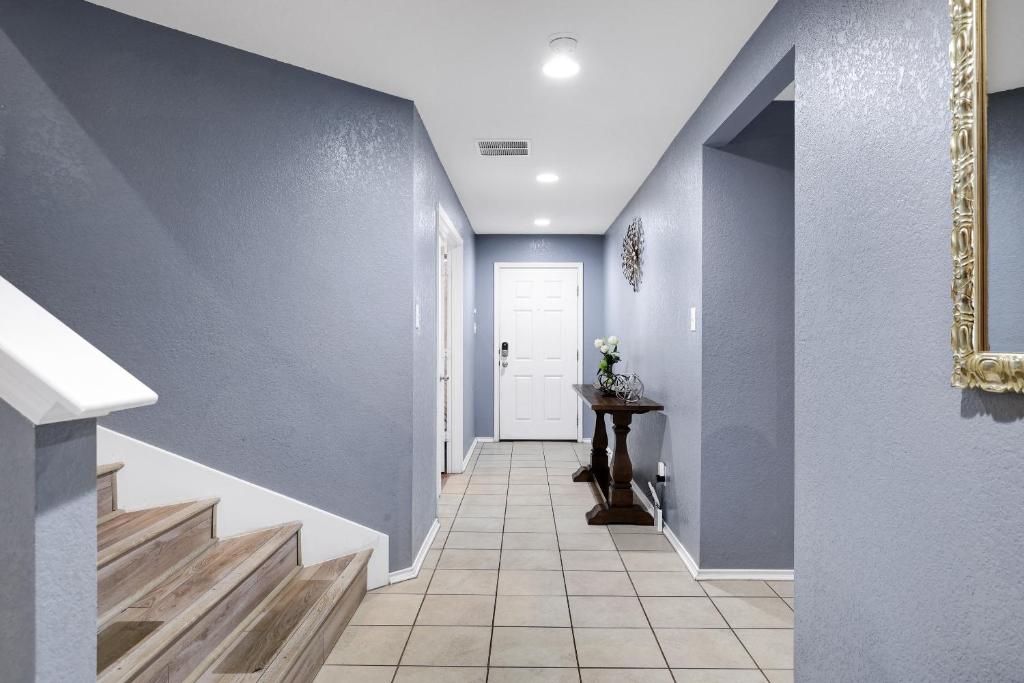 圣安东尼奥Tranquility - A Birdy Vacation Rental的一条带蓝色墙壁和白色门的走廊