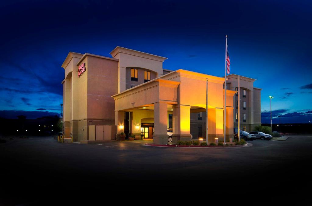 盖洛普Hampton Inn & Suites Gallup的停车场内悬挂美国国旗的建筑物