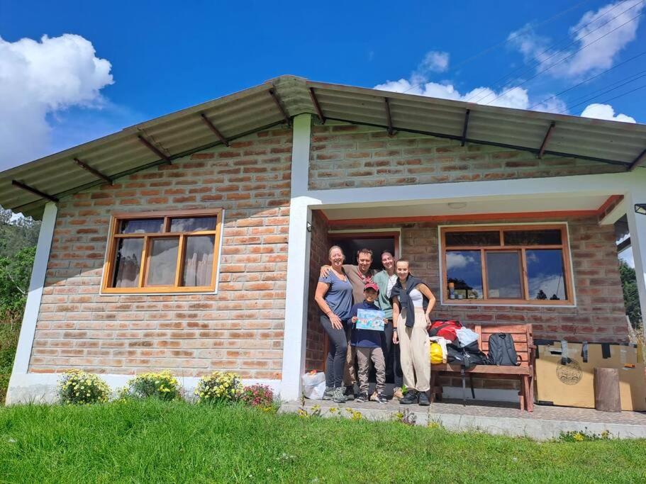 奥塔瓦洛Cozy cabin in the countryside Otavalo Learning的一群站在房子前面的人