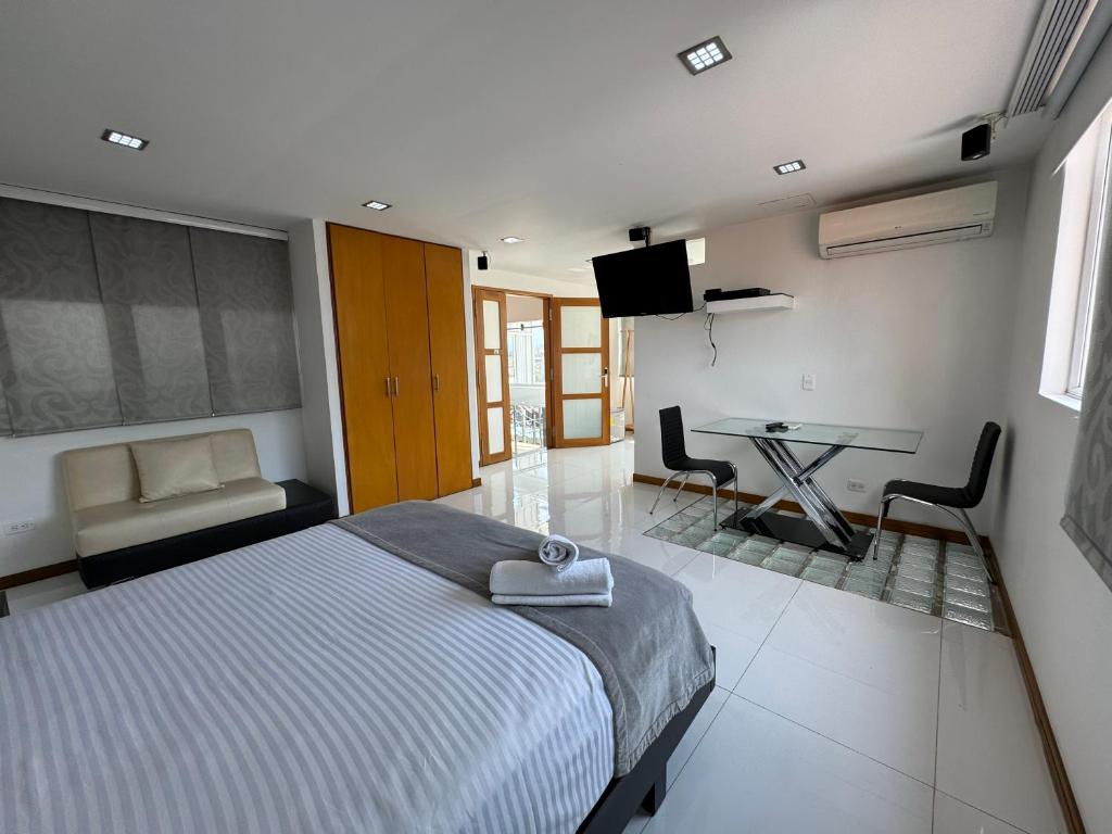 卡利HOTEL SAN ANTONIO PLAZA的一间卧室配有一张床、一张桌子和一张书桌