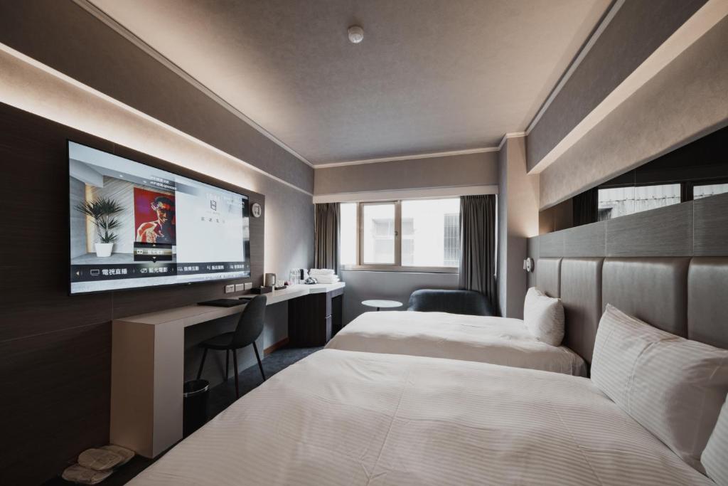 高雄高雄旅居文旅一心馆 的酒店客房设有两张床和一台平面电视。