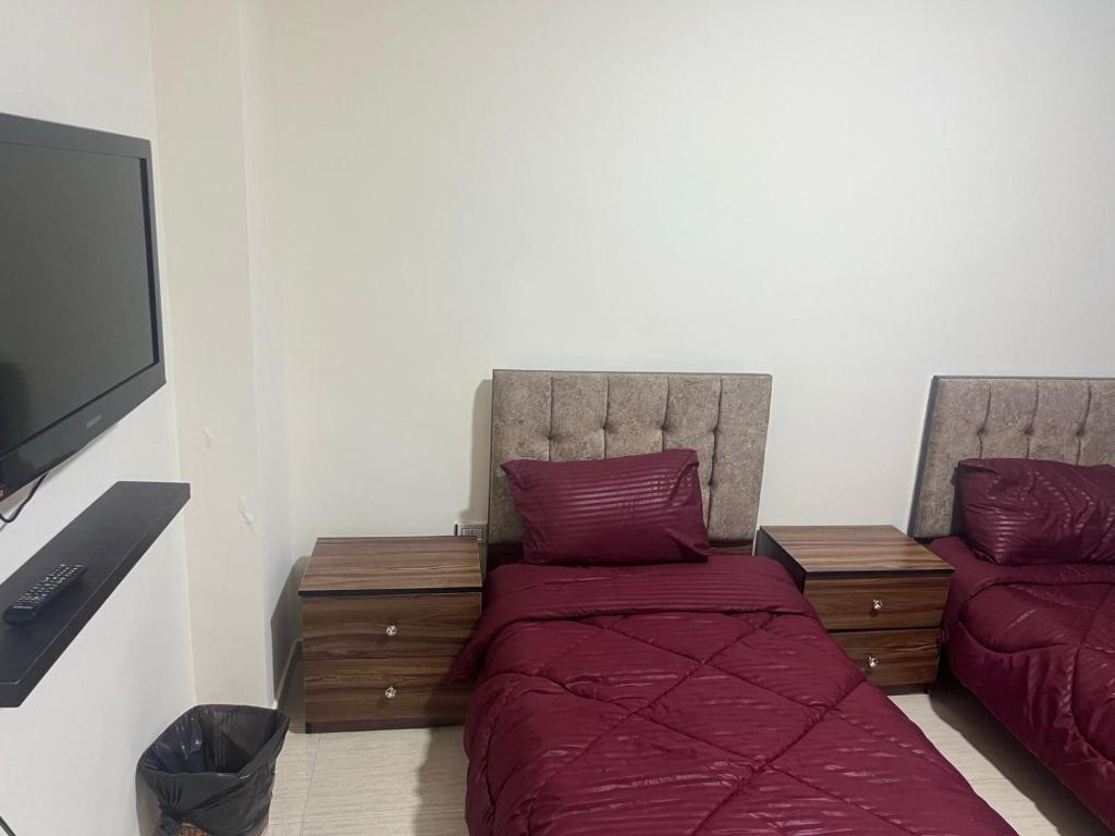 安曼Elegant apartments for rent.的一间卧室配有一张床和一台平面电视
