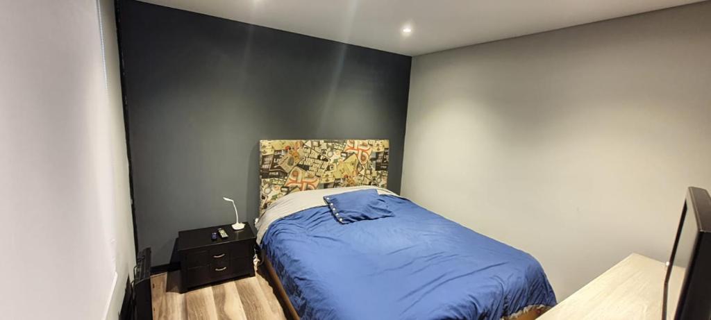 奇亚Apartaestudio en Chía的一间卧室设有蓝色的床和墙壁