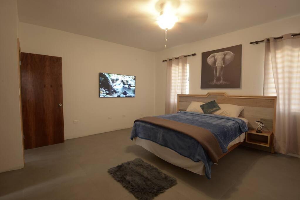 瓦利Sunset Seclusion.的卧室配有一张床,墙上配有电视。