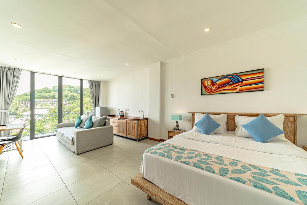 纳闽巴霍Komodo Suites Downtown Managed by CPM Bali的一间卧室配有一张特大号床和一把椅子