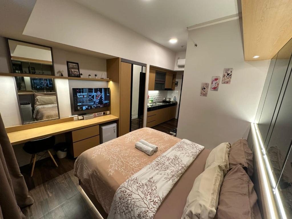 当格浪LUXURY CASA DE PARCO Apartment Near AEON MALL, THE BREEZE, ICE BSD的一间卧室配有一张床、一张书桌和一台电视