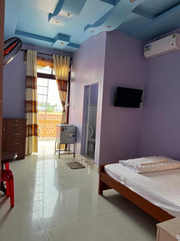 Ấp Tân Phú (1)Khách Sạn Như Ý的一间卧室配有一张蓝色天花板的床