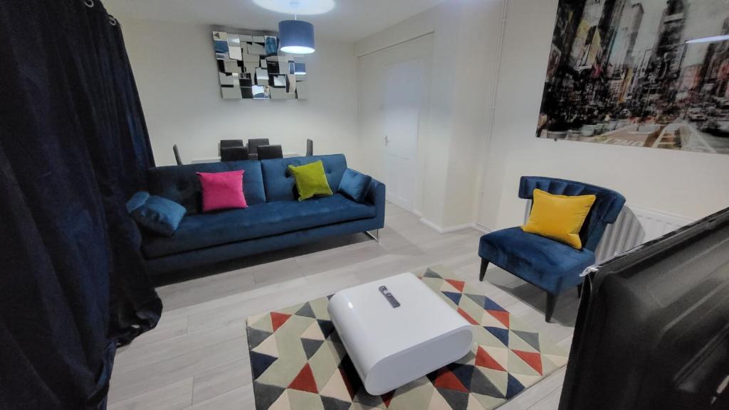 伦敦Garland Modern Close To Station 3 Bedroom City Apartment的客厅配有蓝色的沙发和两把椅子