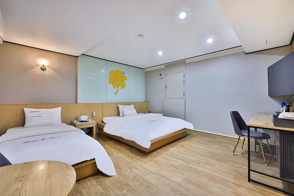 首尔Flower Hotel的酒店客房设有两张床和电视。