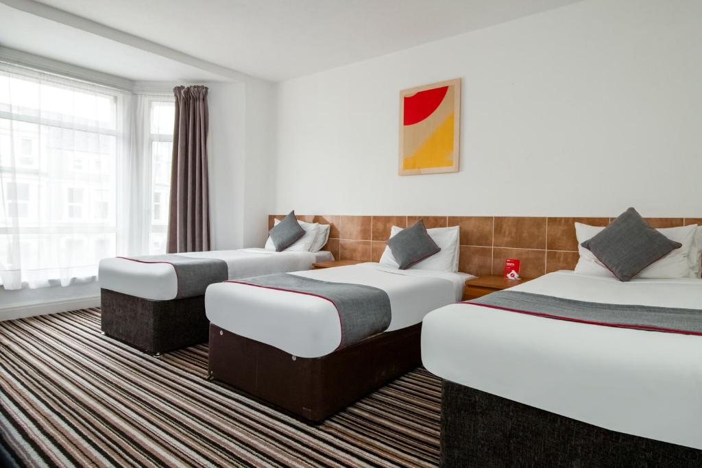 South BankOYO The Contractor Hotel的酒店客房设有三张床和窗户。
