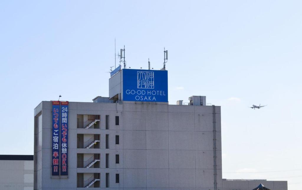丰中グッドホテル大阪的上面有蓝色标志的建筑