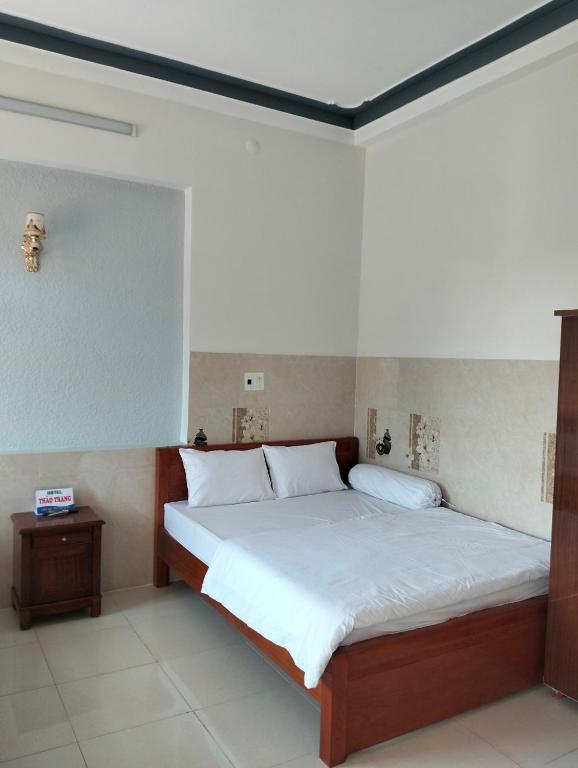 广义Khách sạn Thảo Trang的一间卧室配有一张带白色床单的大床