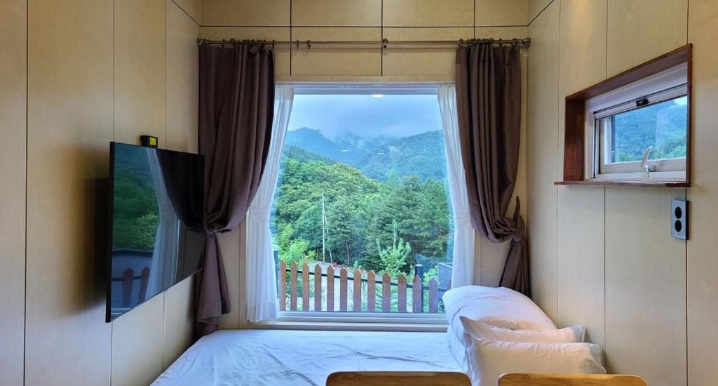 JecheonStarium Jecheon的卧室设有山景大窗户