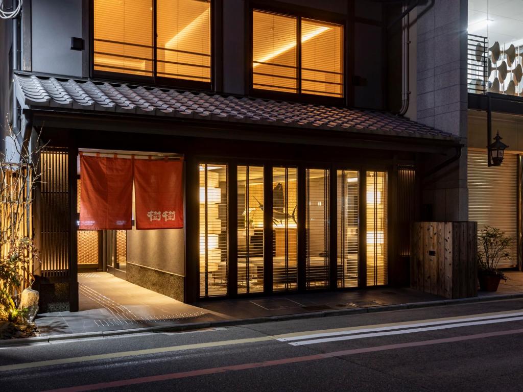 京都Tabist kiki HOTEL KYOTO Sanjo Takakura的街上的一座建筑,晚上有窗户