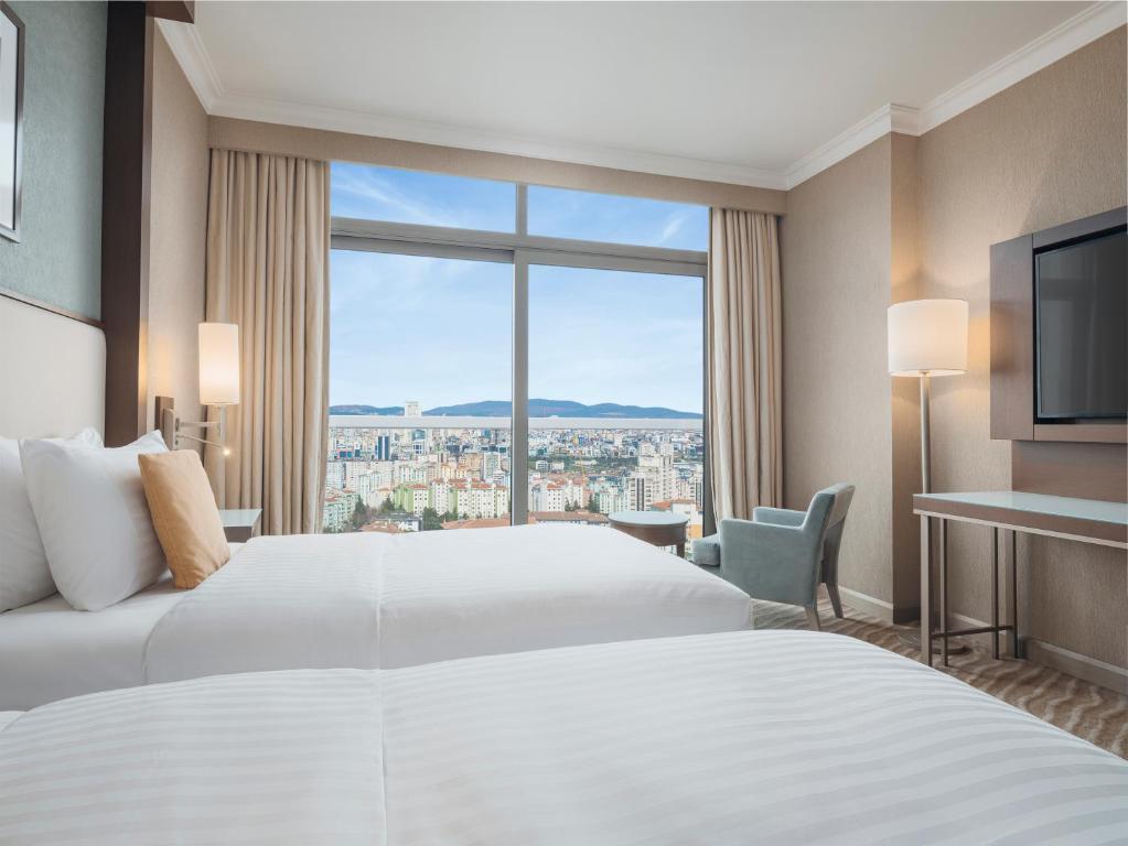 伊斯坦布尔Selectum City Ataşehir的酒店客房设有两张床和大窗户。