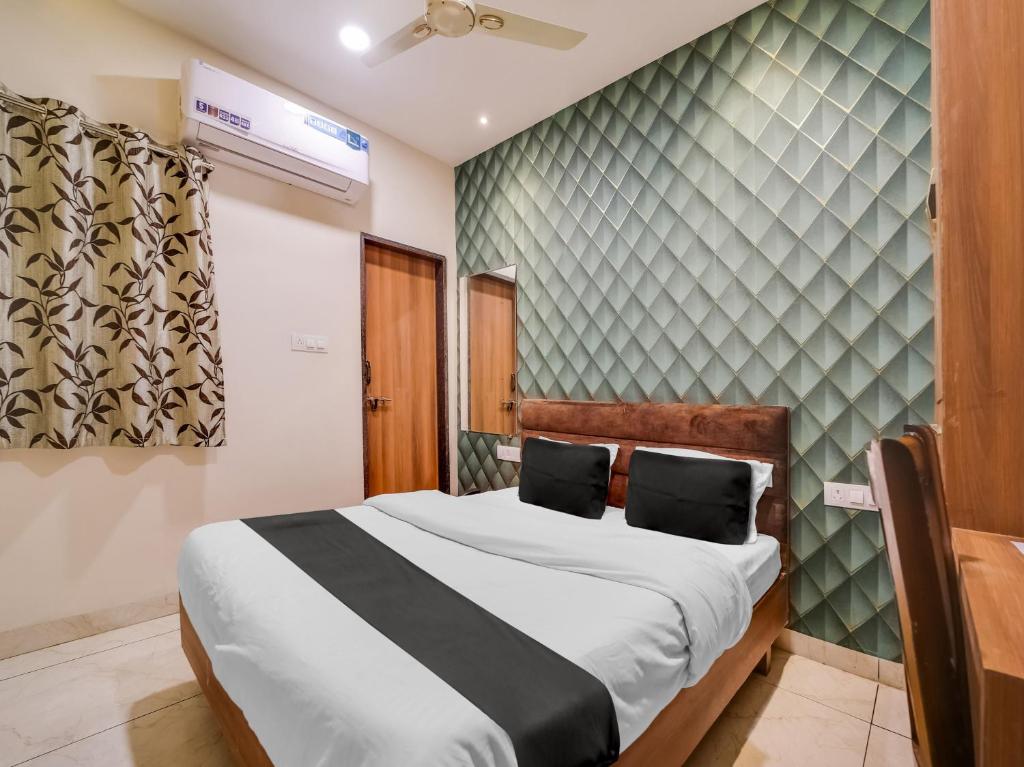 博帕尔Collection O Zamzam Residency的一间卧室设有一张床和一面墙