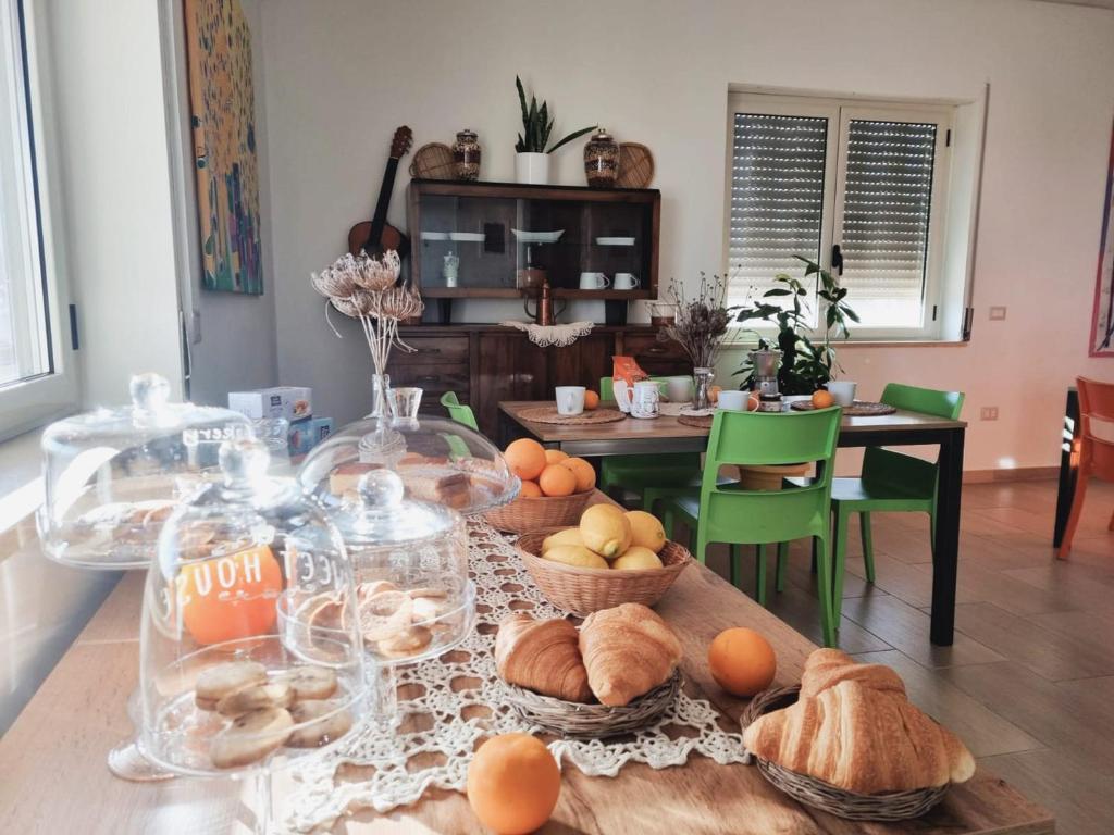 伊索拉迪卡波里祖托Agri B&B Terre Joniche的一张桌子,上面放着一大堆面包和一篮子的食物