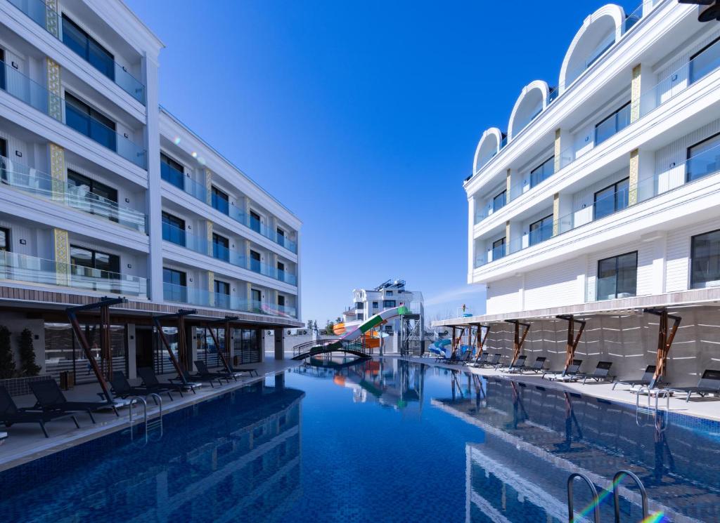 贝莱克Belenli Resort Hotel的一座酒店,在一座建筑旁边设有游泳池