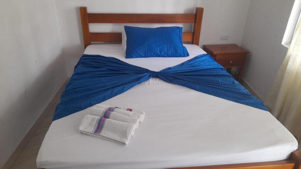 比亚维森西奥Hotel Zarina的一张白色的床,上面有蓝色的弓形