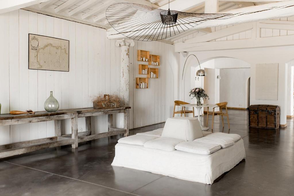 圣马迪拉莫Mas de la Fouque - Hôtel & Spa的客厅配有白色的沙发和桌子