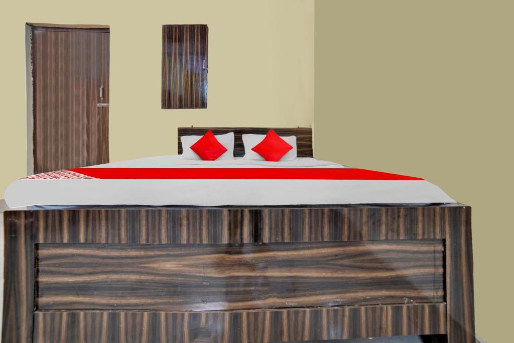 贾姆谢德布尔OYO Flagship Prakash Inn的木制平台上一张带红色枕头的床