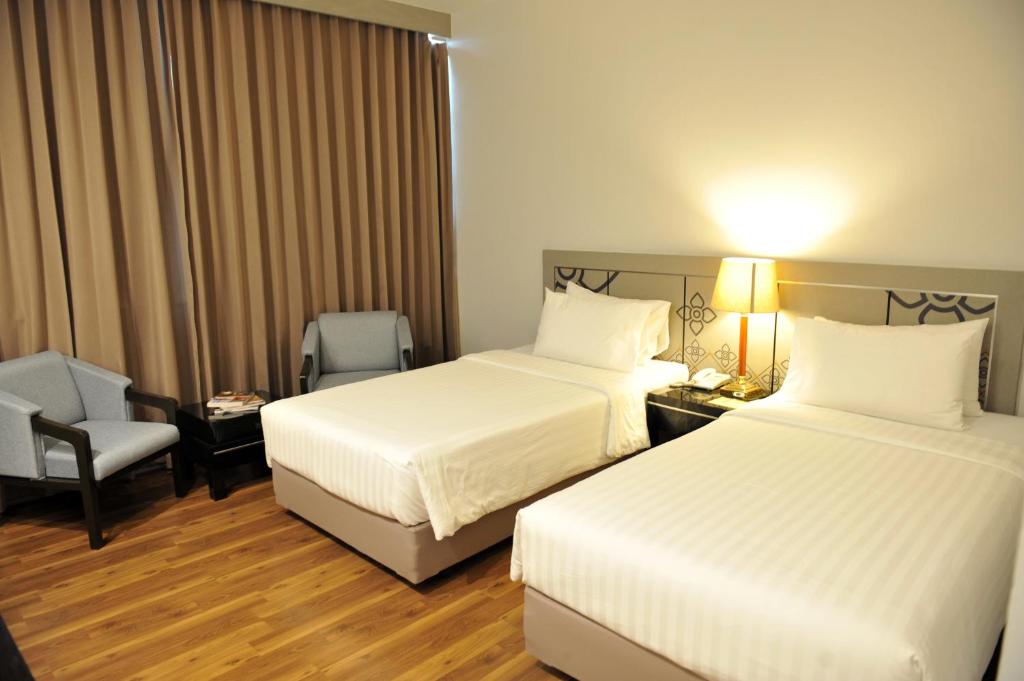 合艾新季节酒店的酒店客房,配有两张床和椅子