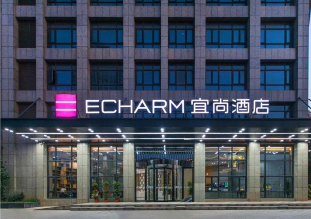 黄花涝Echarm Hotel Wuhan Tianhe Airport Outlets的前面有标志的建筑