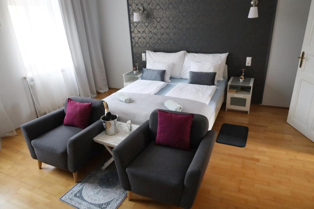 格拉茨Arena Apartments的一间卧室配有一张大床和两把椅子