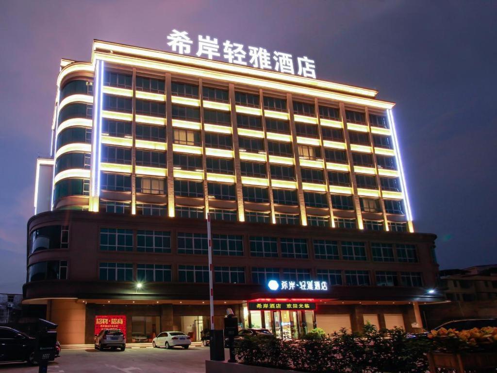 RuhuXana Lite Huizhou Railway Station的一座大建筑,上面有标志
