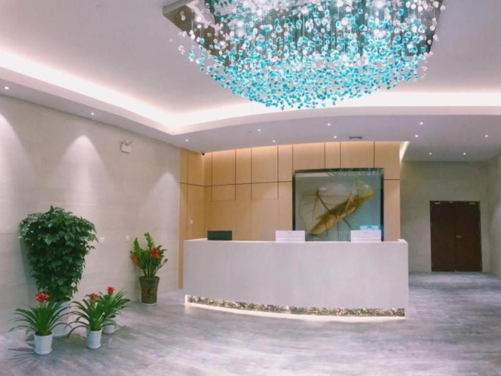 TanbaiGreenTree Inn Express Guangxi Nanning Mingyang Avenue Nanning Airport的大楼内带蓝色吊灯的大堂