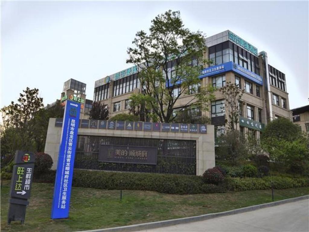 昆明City Comfort Inn Kunming Flower City Midea Shuncheng Mansion的前面有标志的建筑