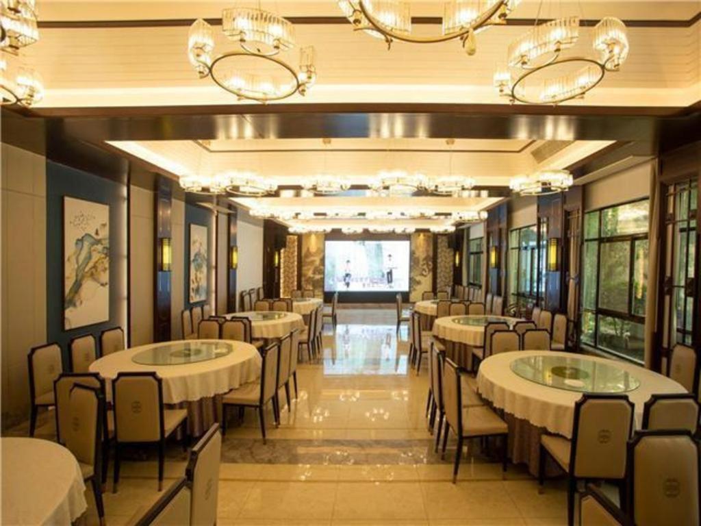 江都City Comfort Inn Yangzhou Jiangdu North Limin Road的宴会厅,配有桌椅