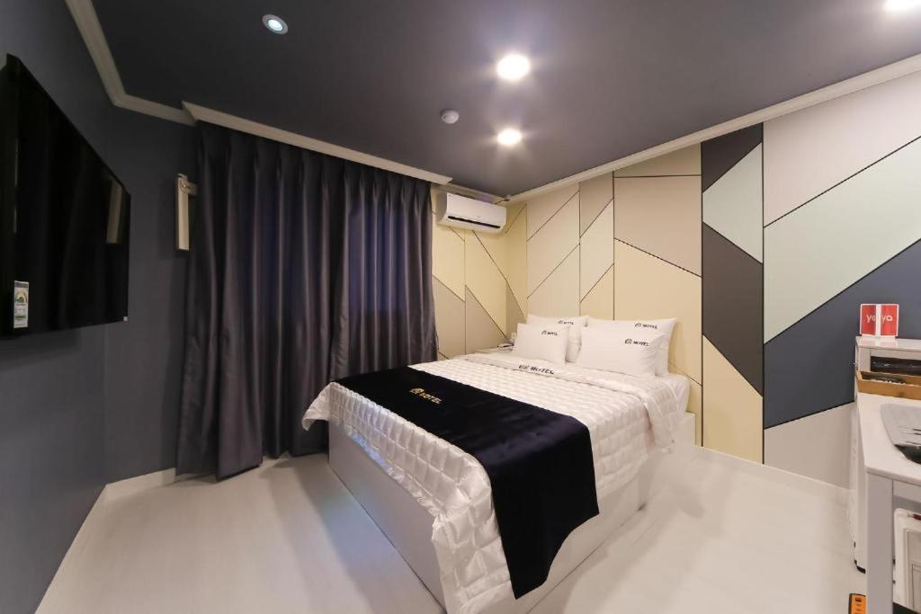 釜山Prince Motel的一间卧室配有一张带白色床单的床和一扇窗户。