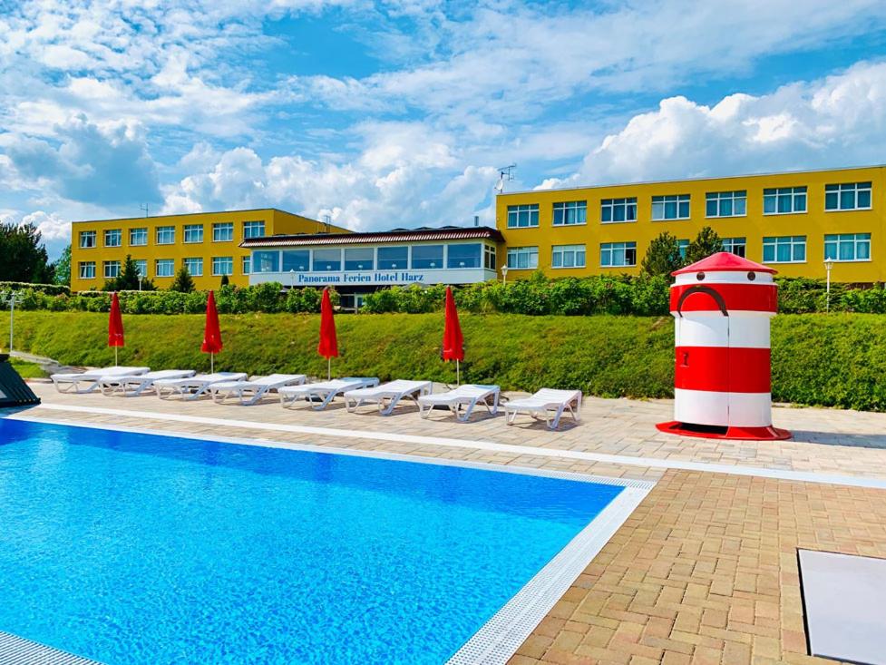 金特斯贝格Panorama Ferien Hotel Harz的一座游泳池,旁边是一座红白色灯塔