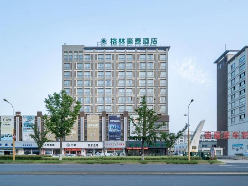 淮安GreenTree Inn Jiangsu Huai'an Qiangjiangpu District Shuidukou Avenue的一座大建筑,上面写着书