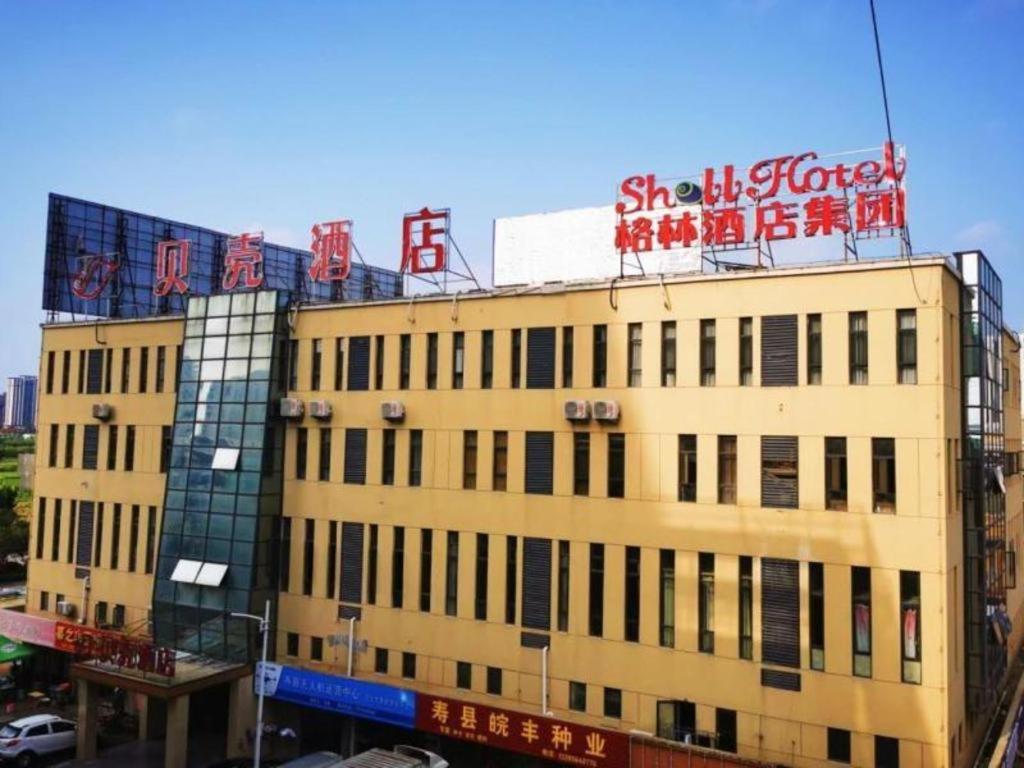 MajiaxuShell Hotel Huainan Shou County Passenger Station Yaohai Grand Market的上面有标志的建筑