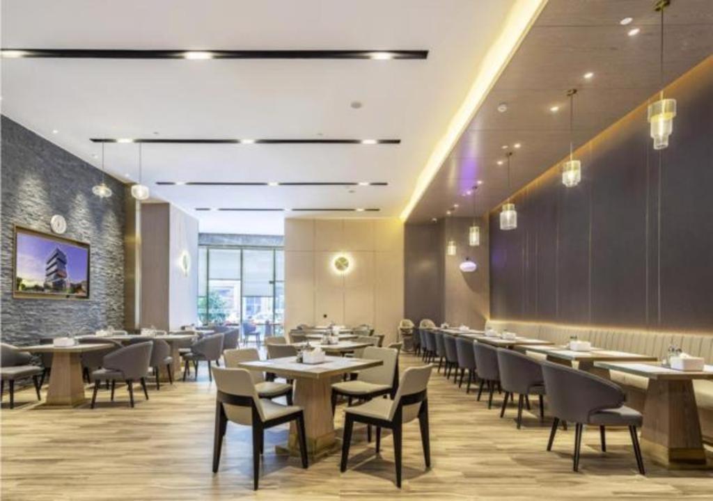 DonghaiPremier City Comfort Hotel Quanzhou Wanda Plaza的一间在房间内配有桌椅的餐厅