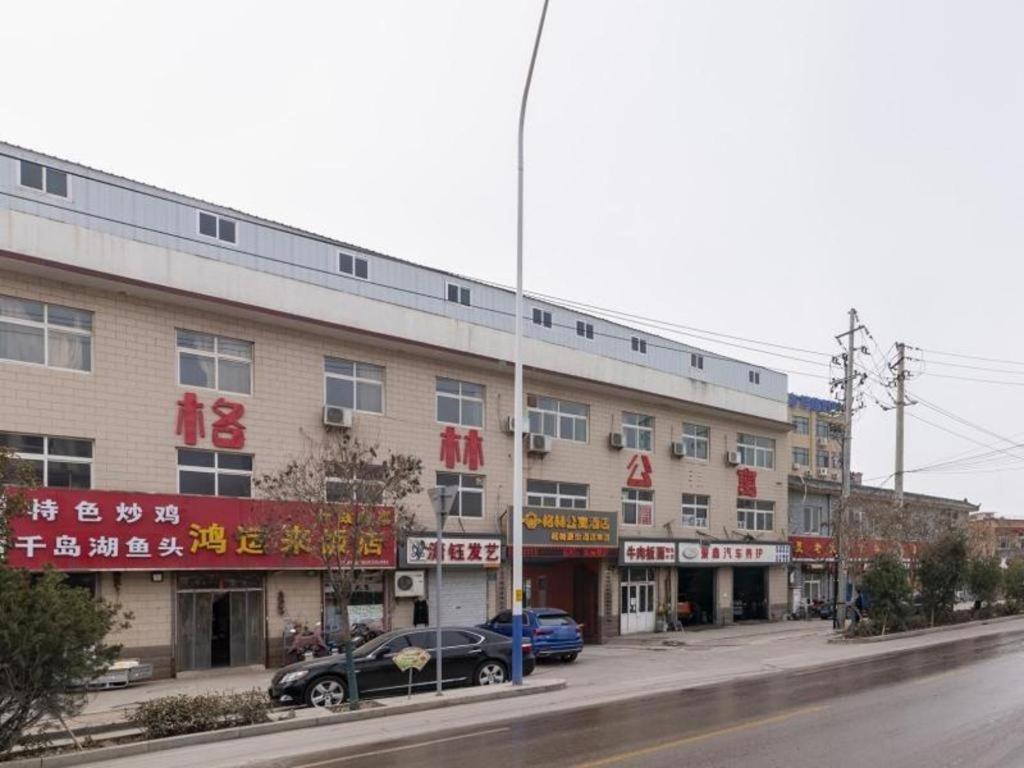 DangjiazhuangGreenTree Apartment Jinan Jiyan Road Shandong Cancer Hospital的城市街道一侧的建筑