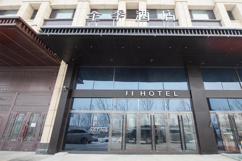 哈尔滨Ji Hotel Harbin West Railway Station的大楼前的j酒店标志