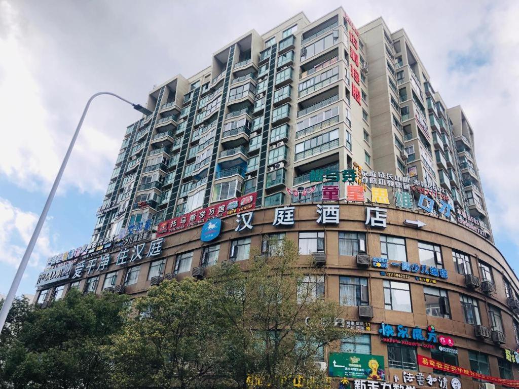 HengdaiqiaoHanting Hotel Wenzhou Leqing Liushi Town的一座高大的建筑,上面有五颜六色的标志