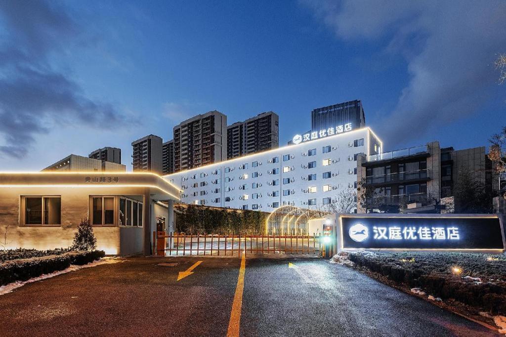 福山Hanting Premium Hotel Yantai Development Zone Golden Beach的前面有标志的酒店大楼