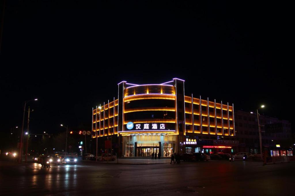 中卫Hanting Hotel Zhongwei Gulou Dong Street的一座在晚上有紫色光的大建筑