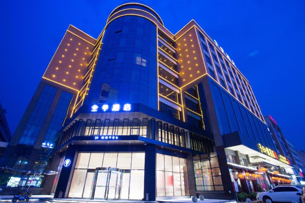花都Ji Hotel Guangzhou Baiyun Airport的一座蓝色的大建筑,上面有灯