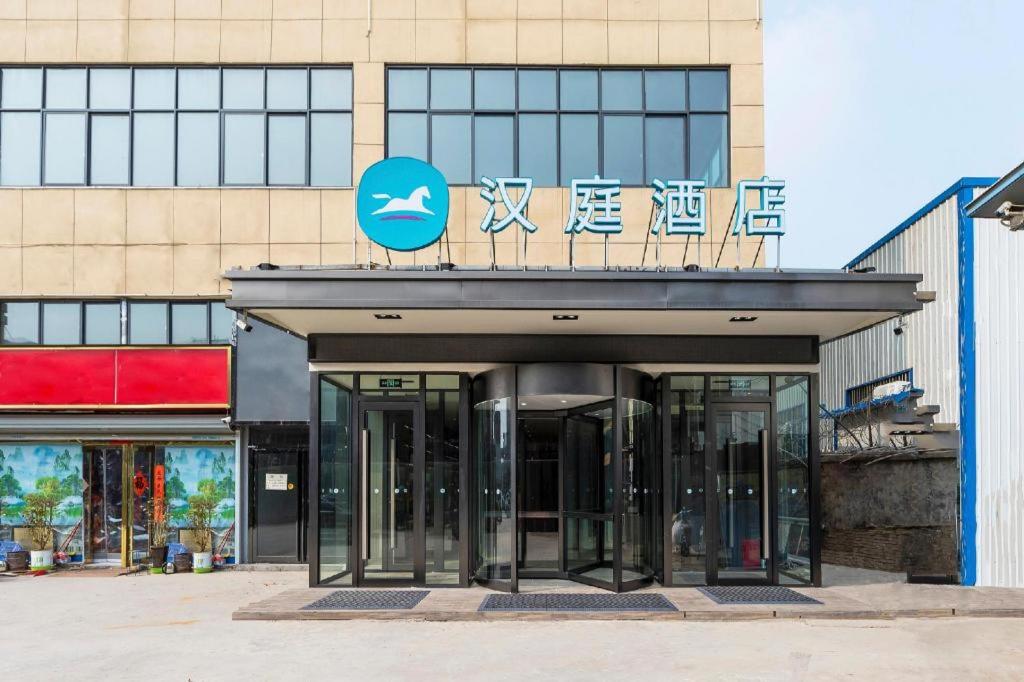 GuodianHanting Hotel Zhengzhou South Longhu Shawoli Metro Station的建筑物入口,上面有标志