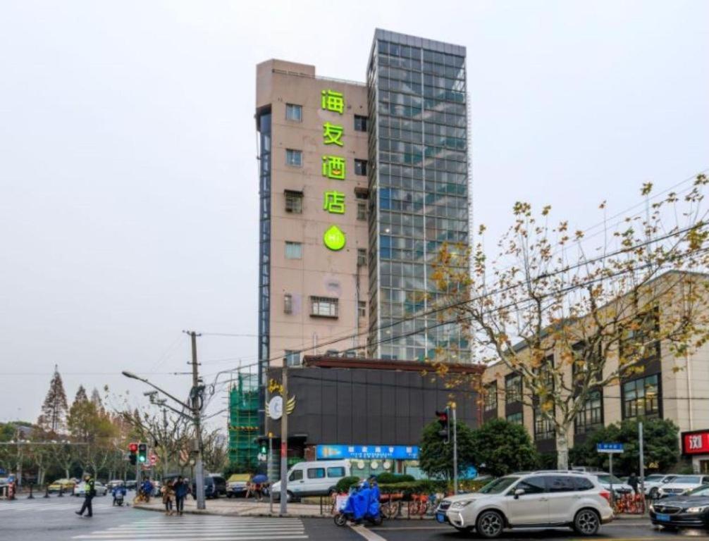 上海Hi Inn Shanghai Xujiahui Caobao Road的一座高大的建筑,旁边是钟