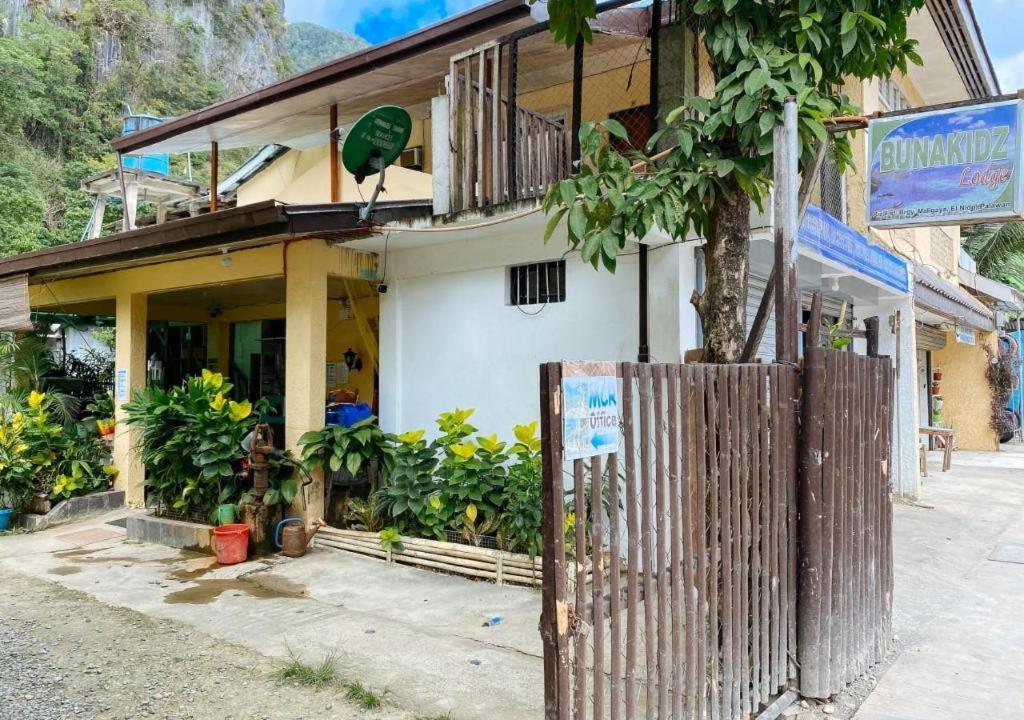 Santa MonicaRedDoorz Hostel @ Bunakidz Lodge El Nido Palawan的前面有栅栏的建筑