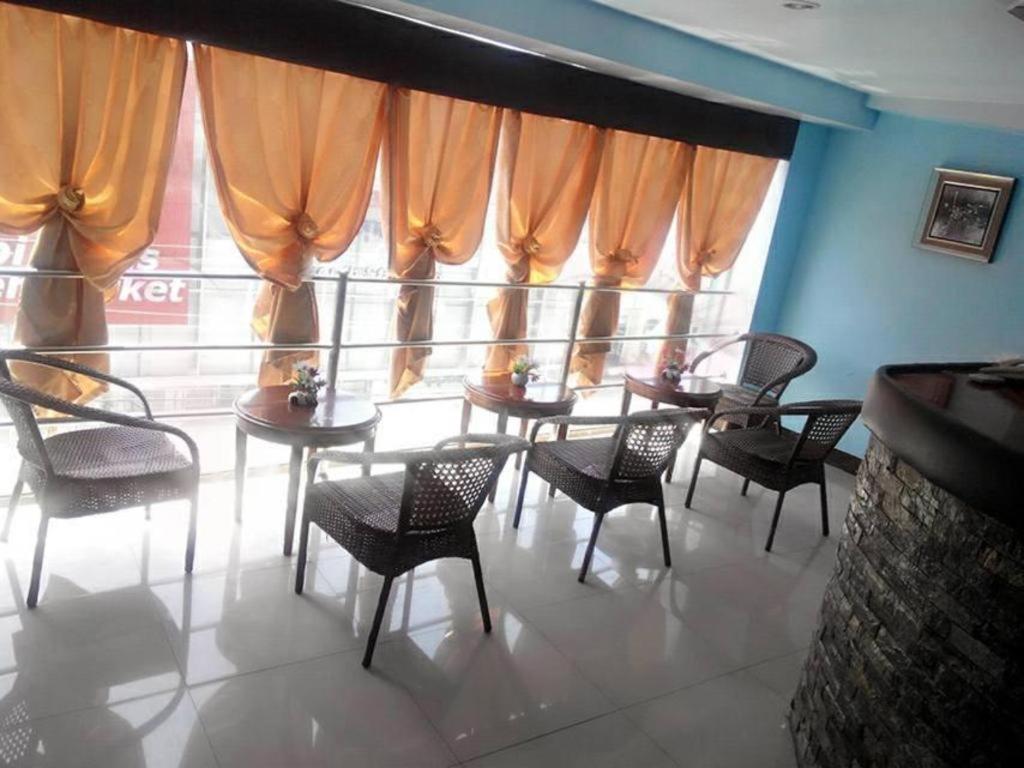 杜马格特Asia Novo Boutique Hotel-Dumaguete的一间带桌椅的用餐室和大窗户