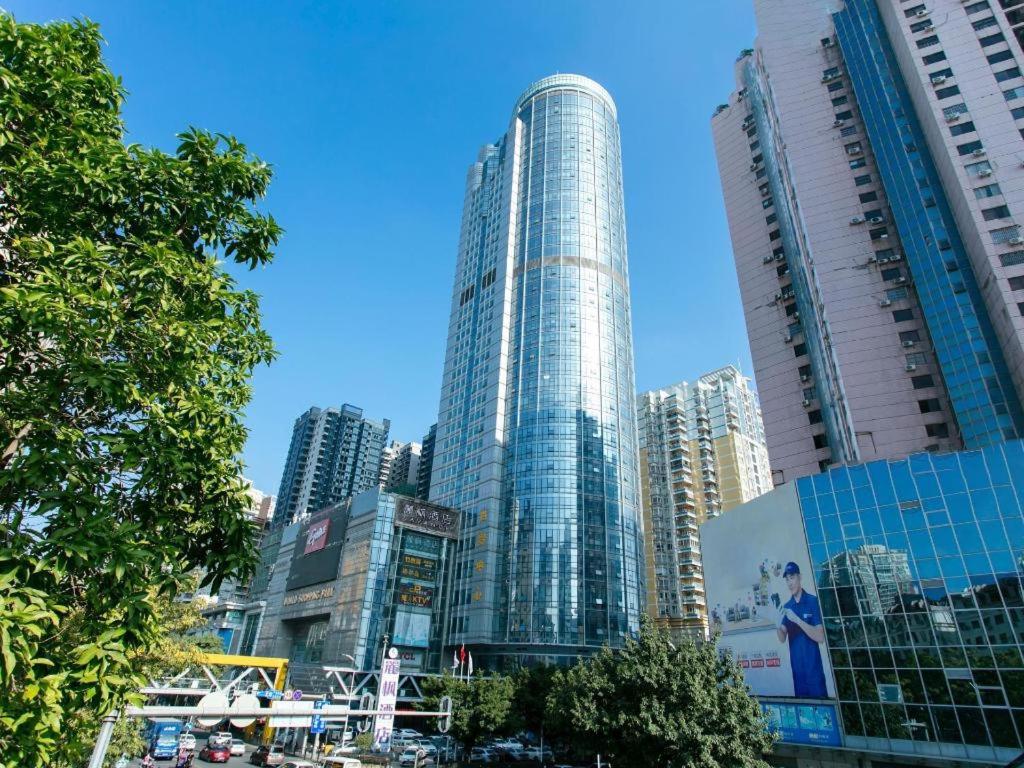 惠州Lavande Hotel Huizhou World Trade Center的一座高大的玻璃建筑,在城市里