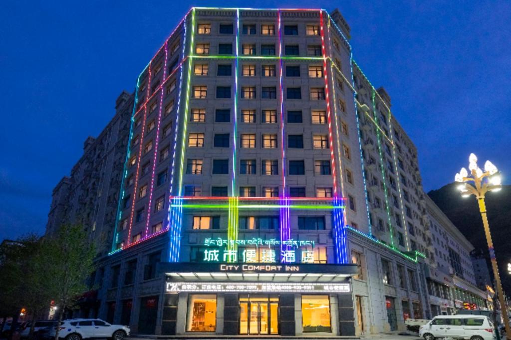乃东City Comfort Inn Shannan Passenger Terminal的建筑的侧面有五颜六色的灯光