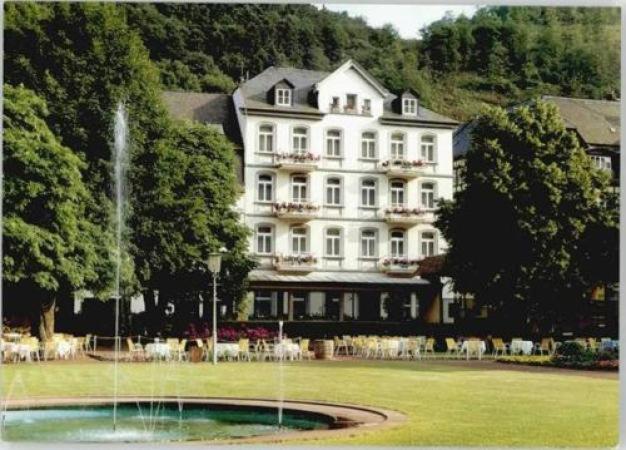 巴特贝特里希Vintagehotel Adler的一座白色的大建筑,前面有一个喷泉